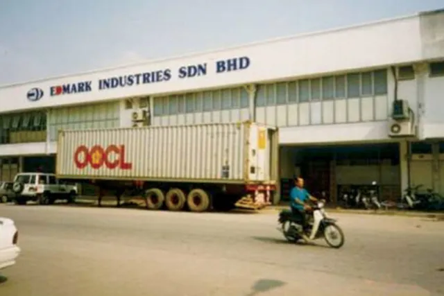 Edmark Industries' first factory in 1989, with a shipping container on a truck outside