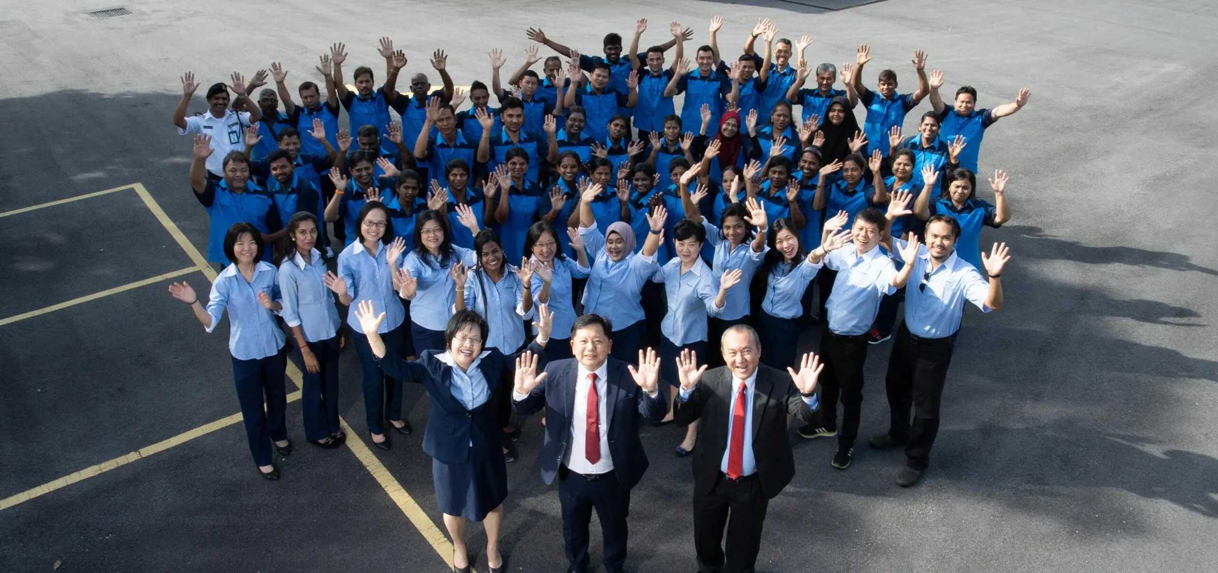 The Edmark Industries team waving at the camera outside the factory